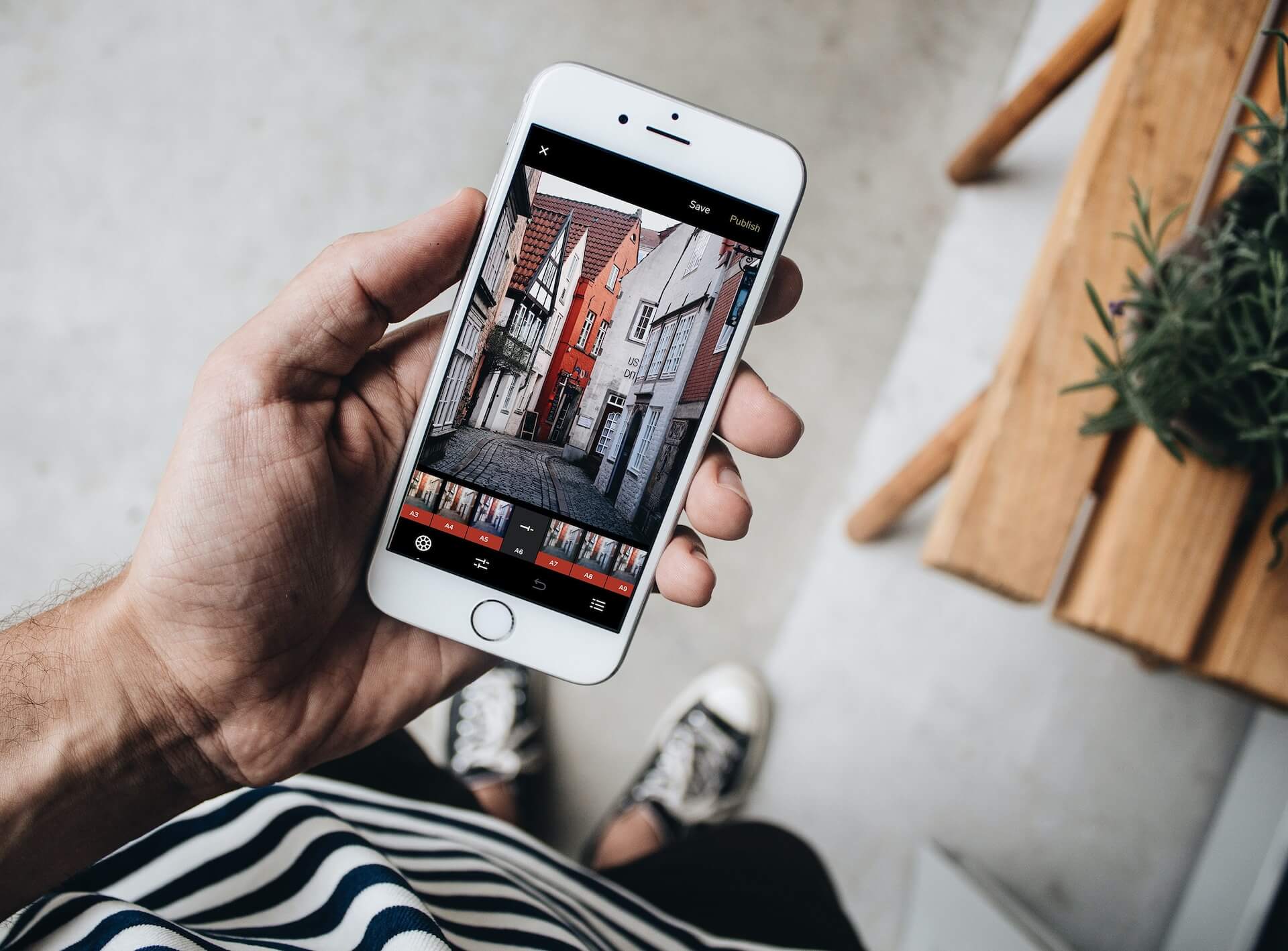 A man holding a smartphone using a photo editing app for social media.